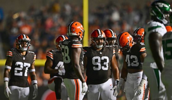 Players from the Cleveland Browns and New York Jets mill about after several banks of stadium lights went out during the second half of the Hall of Fame preseason game Thursday night in Canton, Ohio.