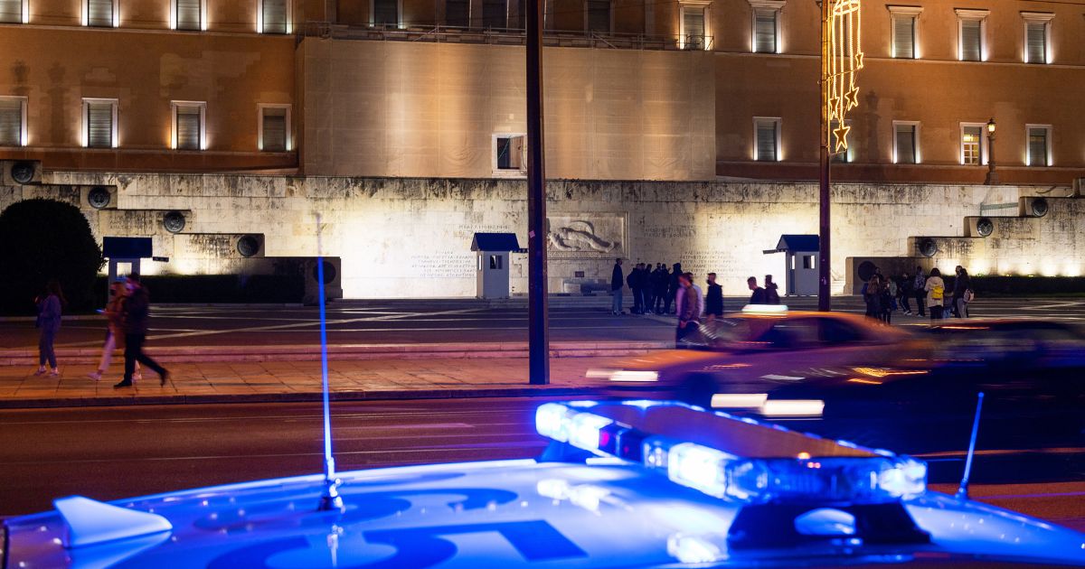 Police lights flash in front of the Greek parliament in Athens in this stock photo. On the Greek island of Corfu, a crime fugitive from Italy was captured while riding a motor scooter, Italian police said Saturday.