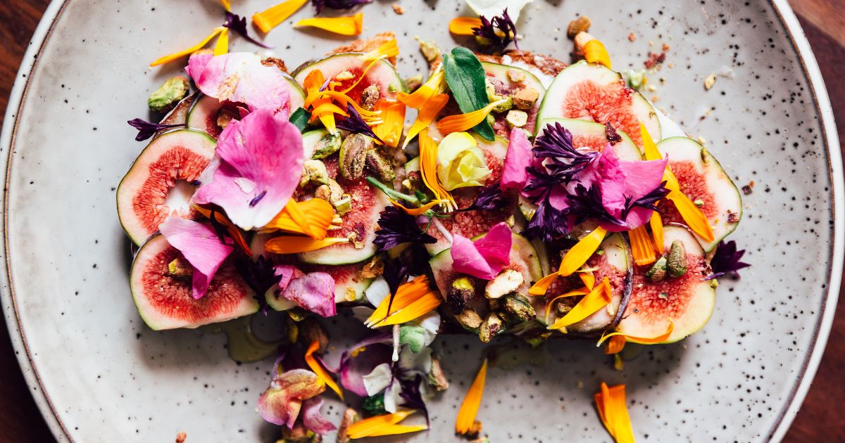 This photo shows fig toast with edible flowers.