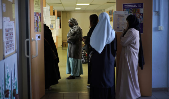 Women wait in line before voting for the first round of the presidential election at a polling station Sunday, April 10, 2022 in the Malpasse northern district of Marseille, southern France.