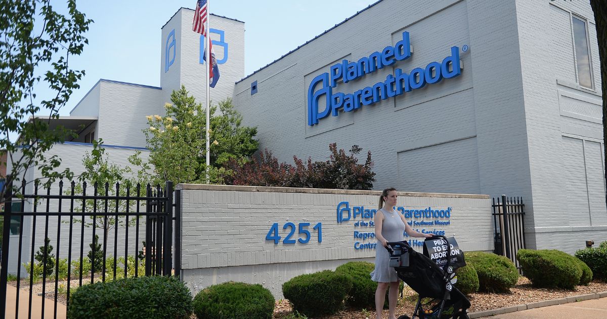 A women stands with her child in a stroller during a pro-life rally outside the Planned Parenthood Reproductive Health Center on June 4, 2019, in St Louis.