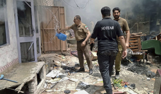 a police officer pours water into a burning house