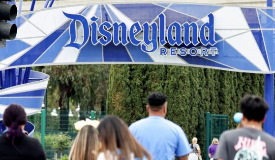 People walk toward an entrance to Disneyland on April 24, in Anaheim, California. Recently, men in dresses were seen greeting young girls wanting to dress up as princesses.