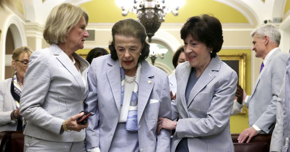 U.S. Sen. Dianne Feinstein (D-CA) (C) is assisted by Sen. Shelley Moore Capito (R-WV) (L), and Sen. Susan Collins (R-ME) (R) after a photo session at the U.S. Capitol on Seersucker Thursday, June 8, 2023 in Washington, DC.