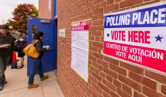 A stock photo shows voters entering a photo site.
