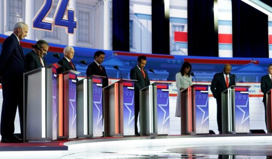 Republican presidential candidates stand on stage and listen to a prayer before a Republican presidential primary debate hosted by FOX News Channel on Wednesday in Milwaukee.