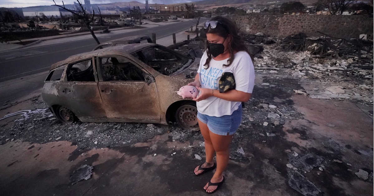Lahaina, Hawaii, resident Summer Gerling holds a piggy bank found in the rubble of her home after fire rampaged through the town Aug. 8. Climate activists were quick to use the disaster as fuel for their arguments, but a professor at the University of Hawaii has a different idea.