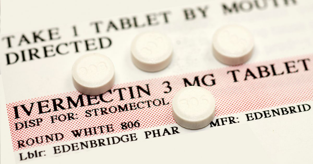 Four ivermectin pills are displayed on top of usage instructions for the drug.