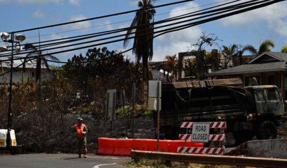 A worker stands by a closed road in the aftermath of the Maui wildfires in Lahaina, Hawaii, on Wednesday. According to the Wall Street Journal, Hawaii regulators and a utility company both knew of fire hazards, but failed to act accordingly.