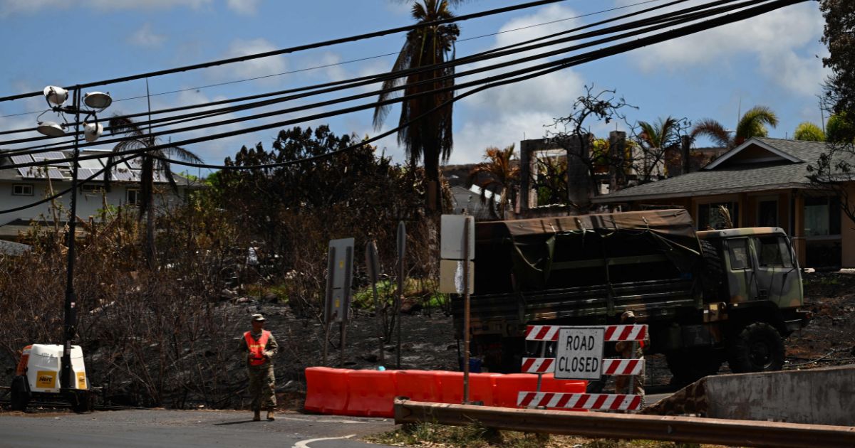 A worker stands by a closed road in the aftermath of the Maui wildfires in Lahaina, Hawaii, on Wednesday. According to the Wall Street Journal, Hawaii regulators and a utility company both knew of fire hazards, but failed to act accordingly.