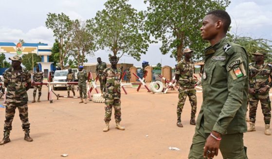 Nigerien soldiers stand guard as supporters of Niger's National Council for the Safeguard of the Homeland (CNSP) gather for a demonstration in Niamey on Friday near a French airbase in Niger.