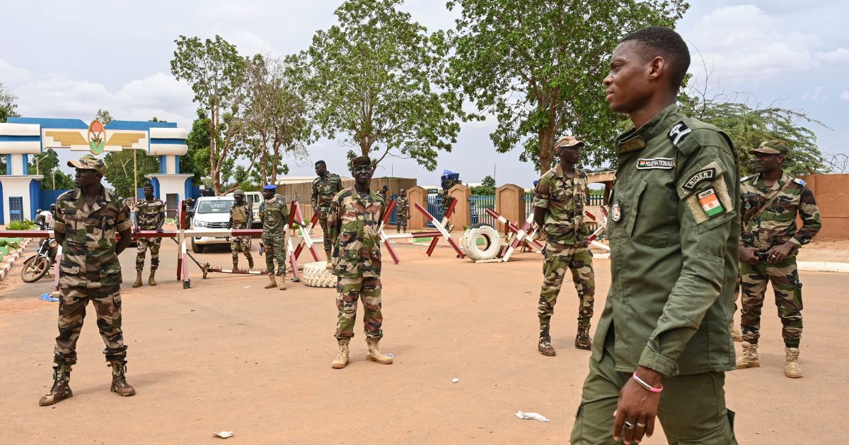 Nigerien soldiers stand guard as supporters of Niger's National Council for the Safeguard of the Homeland (CNSP) gather for a demonstration in Niamey on Friday near a French airbase in Niger.