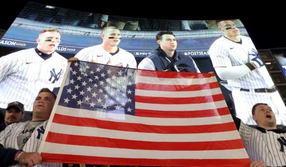 Fans display an American flag during the singing of 'God Bless America' in game five of the American League Division Series between the Cleveland Guardians and New York Yankees at Yankee Stadium on October 18, 2022 in New York, New York.