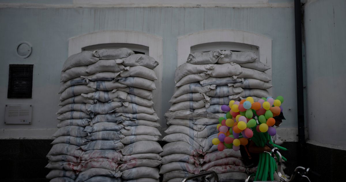 A man sells balloons next to piles of sandbags blocking windows of an old building in Kyiv, Ukraine, on Saturday.