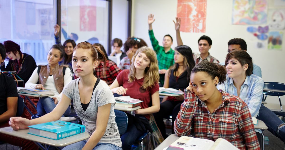 This stock image shows teenage students in a classroom setting.