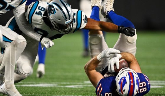 Tommy Sweeney #89 of the Buffalo Bills is brought down by Josh Watson #94 of the Carolina Panthers in the fourth quarter during a preseason game at Bank of America Stadium on August 26, 2022 in Charlotte, North Carolina.