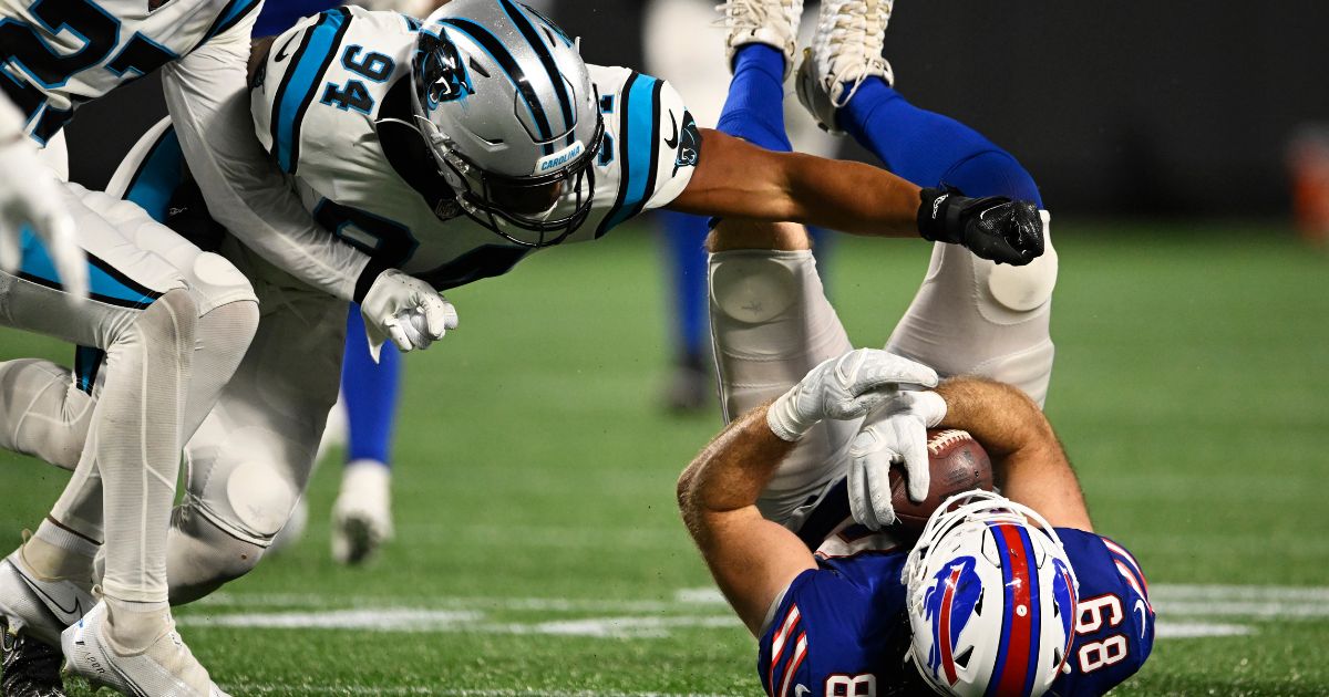 Tommy Sweeney #89 of the Buffalo Bills is brought down by Josh Watson #94 of the Carolina Panthers in the fourth quarter during a preseason game at Bank of America Stadium on August 26, 2022 in Charlotte, North Carolina.