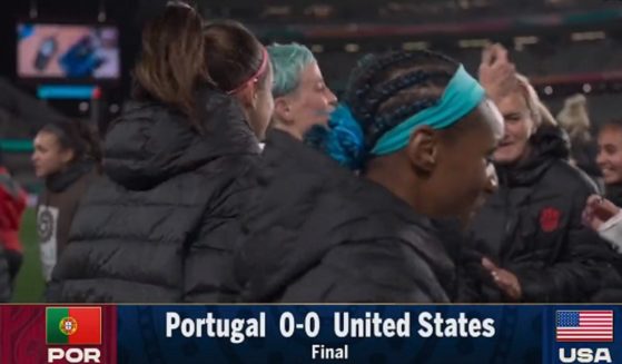 Controversial soccer player Megan Rapinoe (blue hair) dances with fellow members of the U.S. Women's National Team after a tie game in New Zealand in the Women's World Cup.
