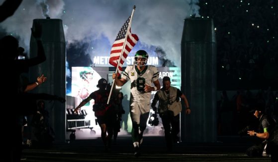 New York Jets quarterback Aaron Rodgers runs onto the field at MetLife Stadium in East Rutherford, New Jersey, on Monday night before the game against the Buffalo Bills.
