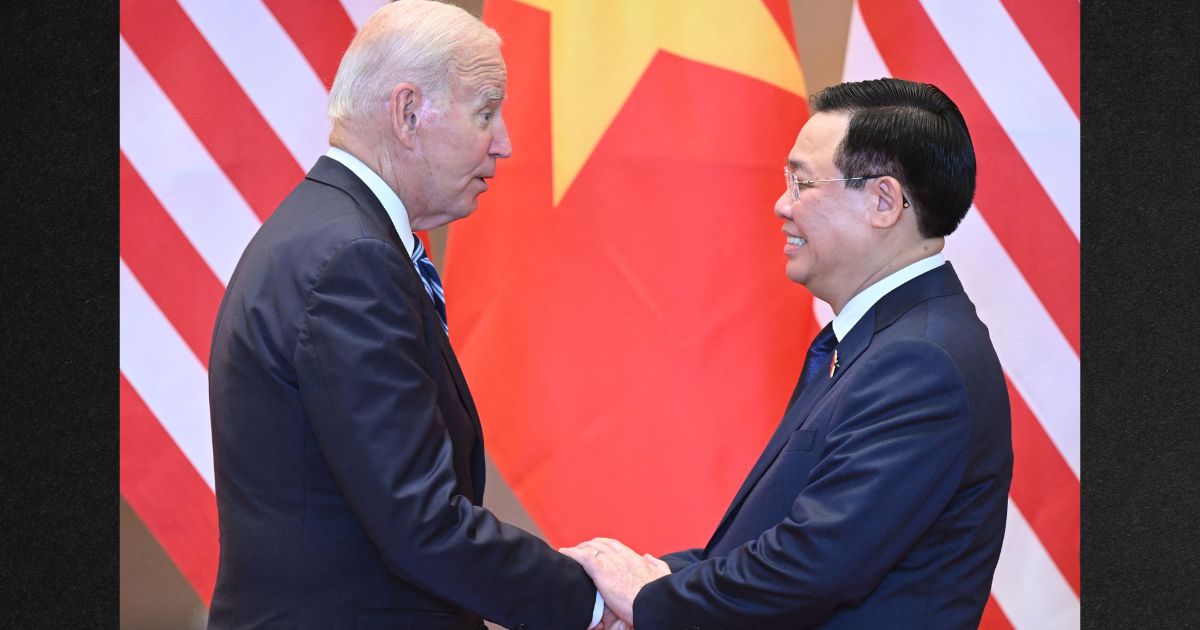 President Joe Biden, left, shakes hands with Vuong Dinh Hue, right, Chairman of Vietnam's National Assembly, during a meeting in Hanoi Monday.