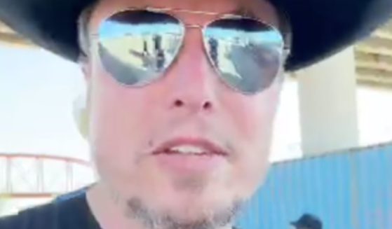 Elon Musk in sunglasses and a black cowboy hat at the border