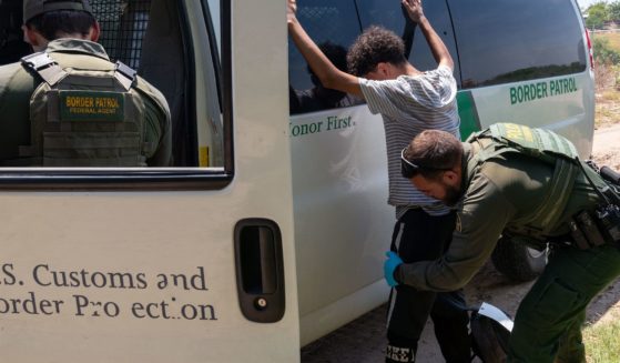 A migrant who has crossed into the US from Mexico in Eagle Pass, Texas gets frisked by a Border Patrol Agent on August 25, 2023.