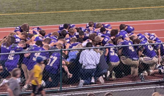 Members of the Karns City High School football team in Pennsylvania pray for their teammate, Mason Martin, on Friday.