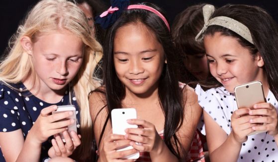 This stock photo shows three young girls on cellphones. A town in Ireland recently banned children from using cellphones.