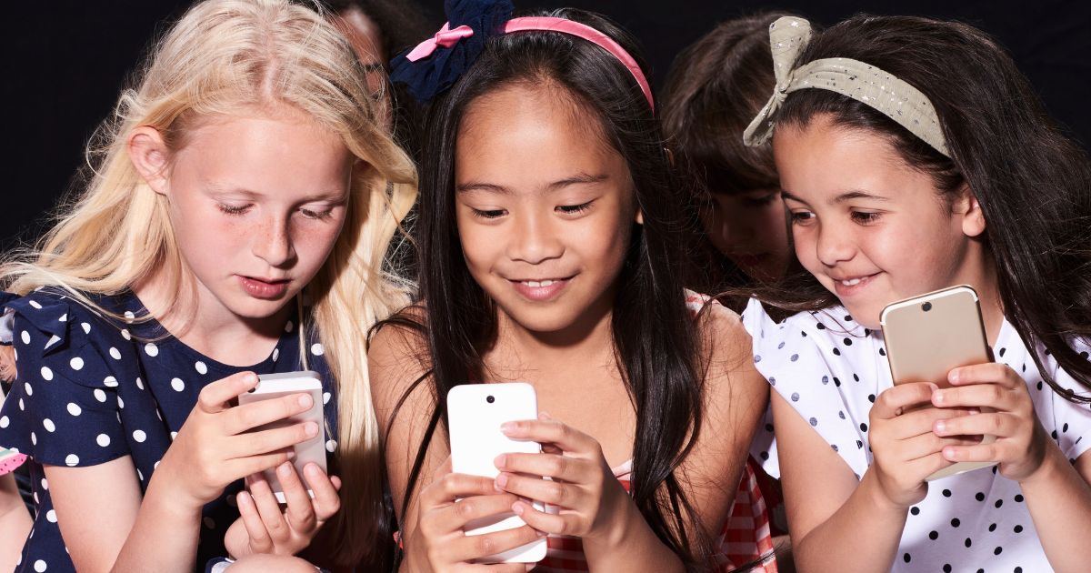This stock photo shows three young girls on cellphones. A town in Ireland recently banned children from using cellphones.