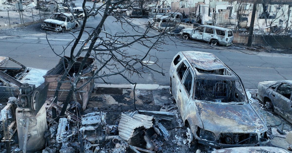 Burned cars and homes are seen in a neighborhood that was destroyed by a wildfire on August 8, in Lahaina, Hawaii. At least 111 people were killed and thousands were displaced after a wind-driven wildfire devastated the towns of Lahaina and Kula on the island of Maui. One man filed a lawsuit Monday, alleging officials' negligence caused his daughter's death.