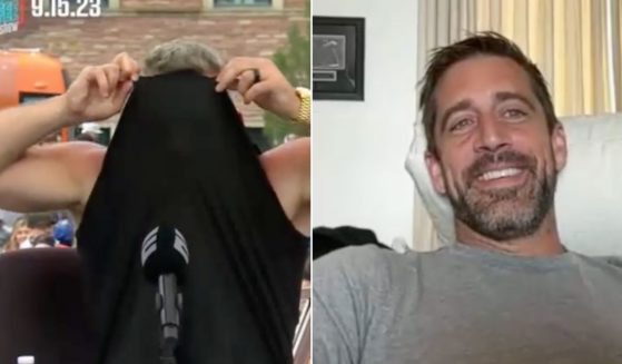 ESPN host and former NFL punter Pat McAfee, left, responded to a quip by Aaron Rodgers, right, by hiding his face inside his shirt.