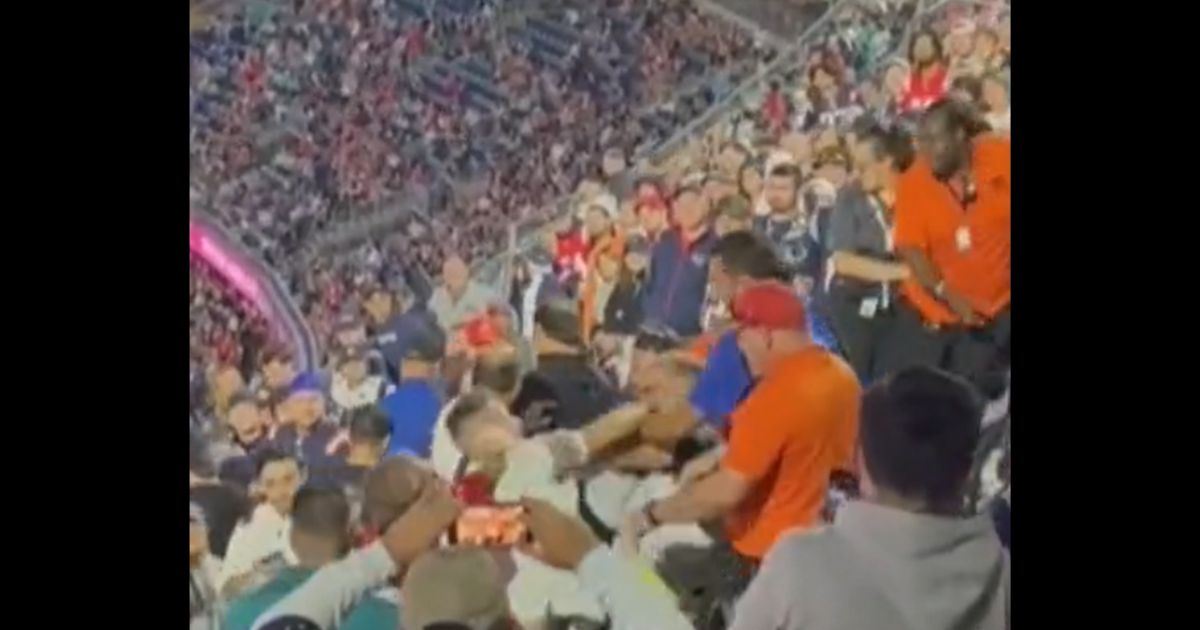 A fight breaks out between fans at a Miami Dolphins-New England Patriots game in Massachusetts on Sunday.