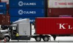 A truck driver prepares to depart with a cargo shipping container from the Port of Los Angeles in Los Angeles, California in this file photo from June 7.