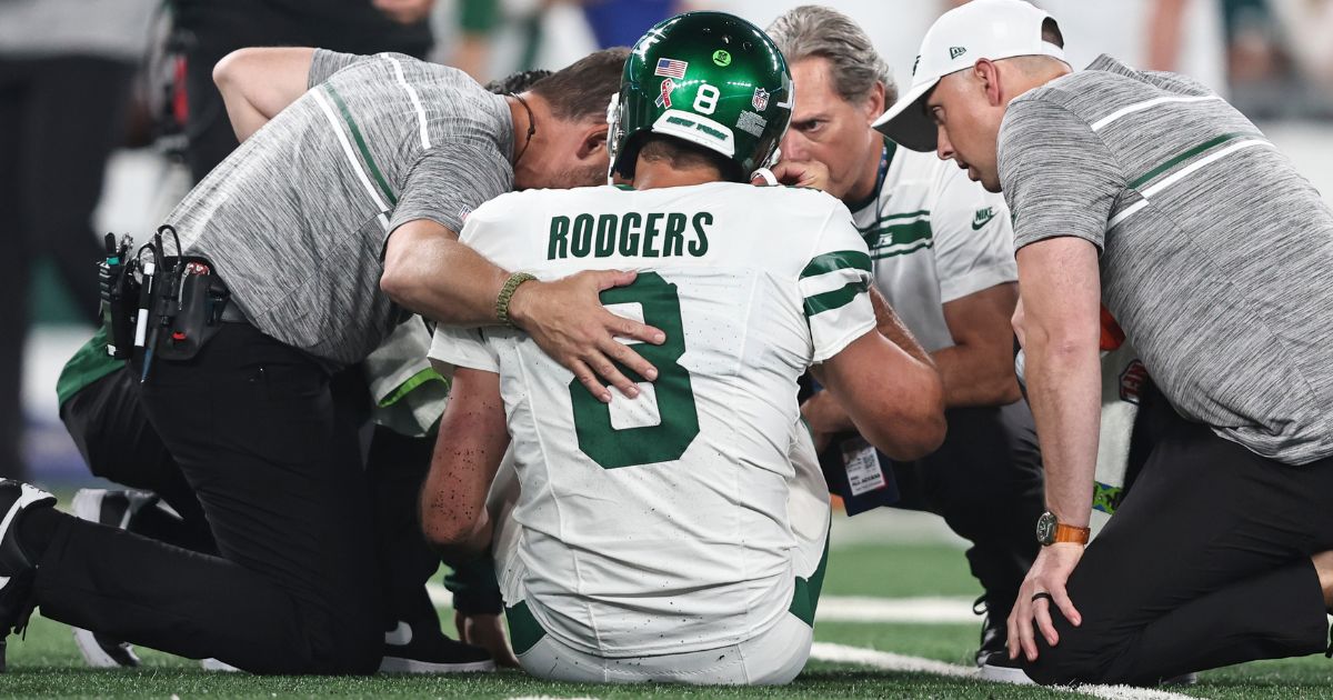 New York Jets quarterback Aaron Rodgers is looked at by the team's medical staff on the field during the first quarter of the Jets' game against the Buffalo Bills at MetLife Stadium on Monday night.