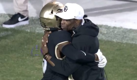 Colorado Buffaloes coach Deion Sanders hugs wide receiver Jimmy Horn after a dropped pass in the third quarter.