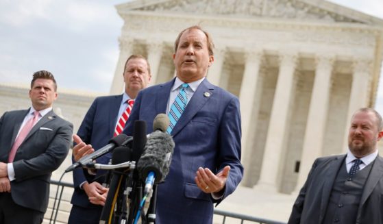 Texas Attorney General Ken Paxton (C) talks to reporters with Missouri Attorney General Eric Schmitt (2nd L) and Texas Solicitor General Judd Stone (R) in front of the U.S. Supreme Court after arguments in their case about Title 42 on April 26, 2022 in Washington, DC.