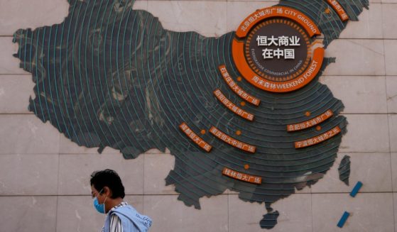 A woman walks past a map showing Evergrande development projects in China, at an Evergrande city plaza in Beijing on Sept. 21, 2021.