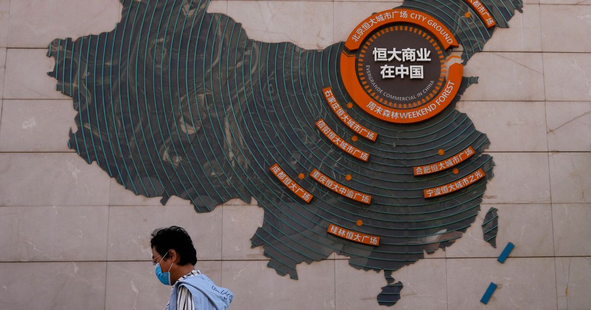 A woman walks past a map showing Evergrande development projects in China, at an Evergrande city plaza in Beijing on Sept. 21, 2021.