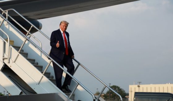 Former U.S. President Donald Trump gives a thumbs up as he arrives at Atlanta Hartsfield-Jackson International Airport on August 24, 2023 in Atlanta, Georgia.