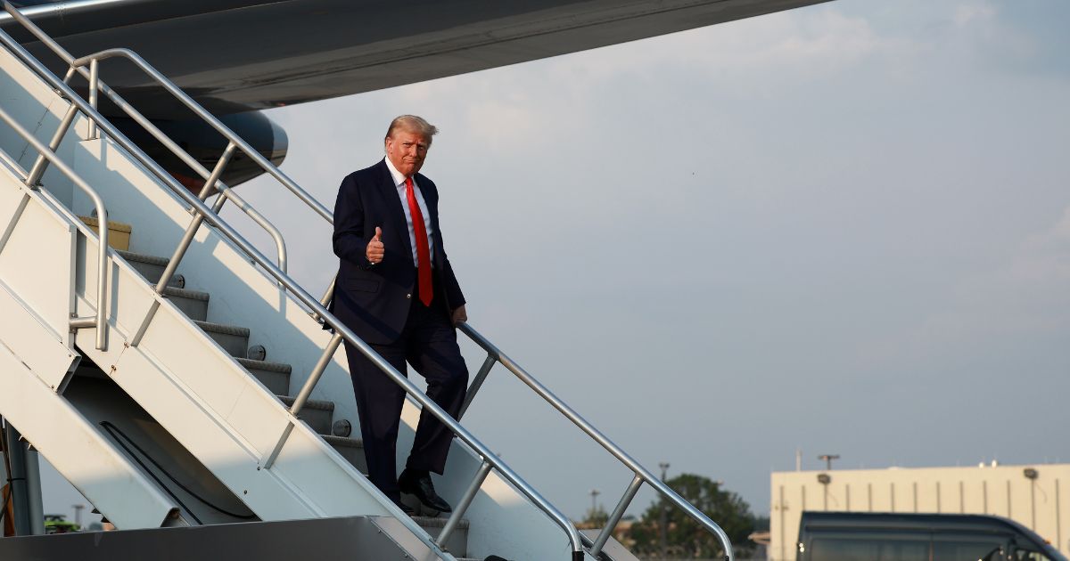 Former U.S. President Donald Trump gives a thumbs up as he arrives at Atlanta Hartsfield-Jackson International Airport on August 24, 2023 in Atlanta, Georgia.