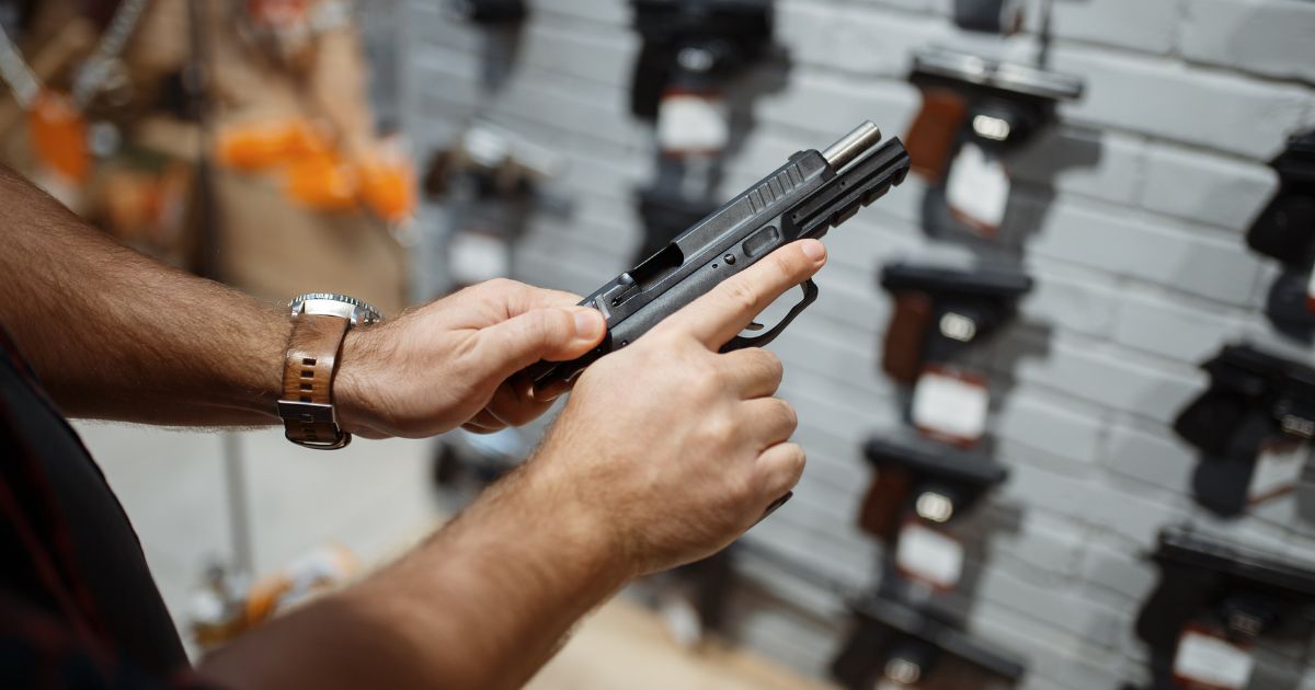 A man examines a gun in the above stock image.