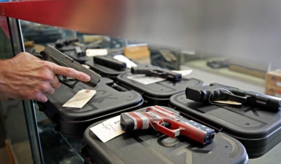 A worker restocks handguns at Davidson Defense in Orem, Utah on March 20, 2020.