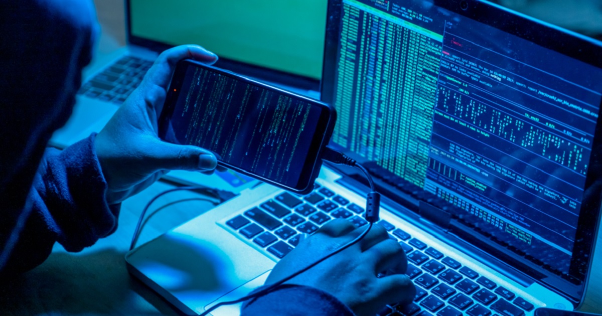A stock image illustrates a computer hacker at work.