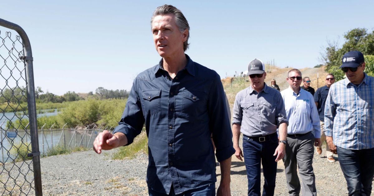 California Governor Gavin Newsom walks along the Lower Yuba River to the Daguerre Point Dam in Marysville, California, on May 16.