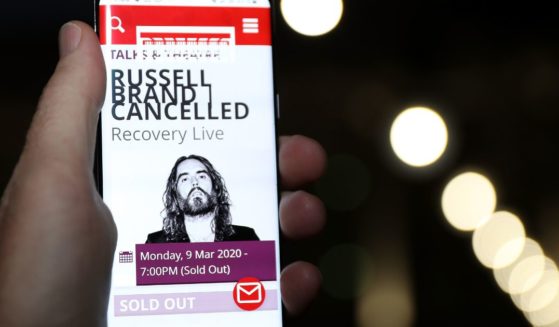 In this photo illustration the web page for the Perth Concert Hall is displayed on a mobile phone advising of the cancelled Russell Brand show on March 9, 2020 in Perth, Australia.