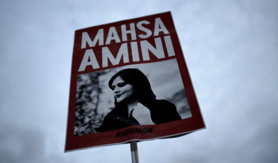 Demonstrators hold a placard with a picture of Iranian woman Mahsa Amini during a protest against her death, in Berlin, Germany, on Sept. 28, 2022.