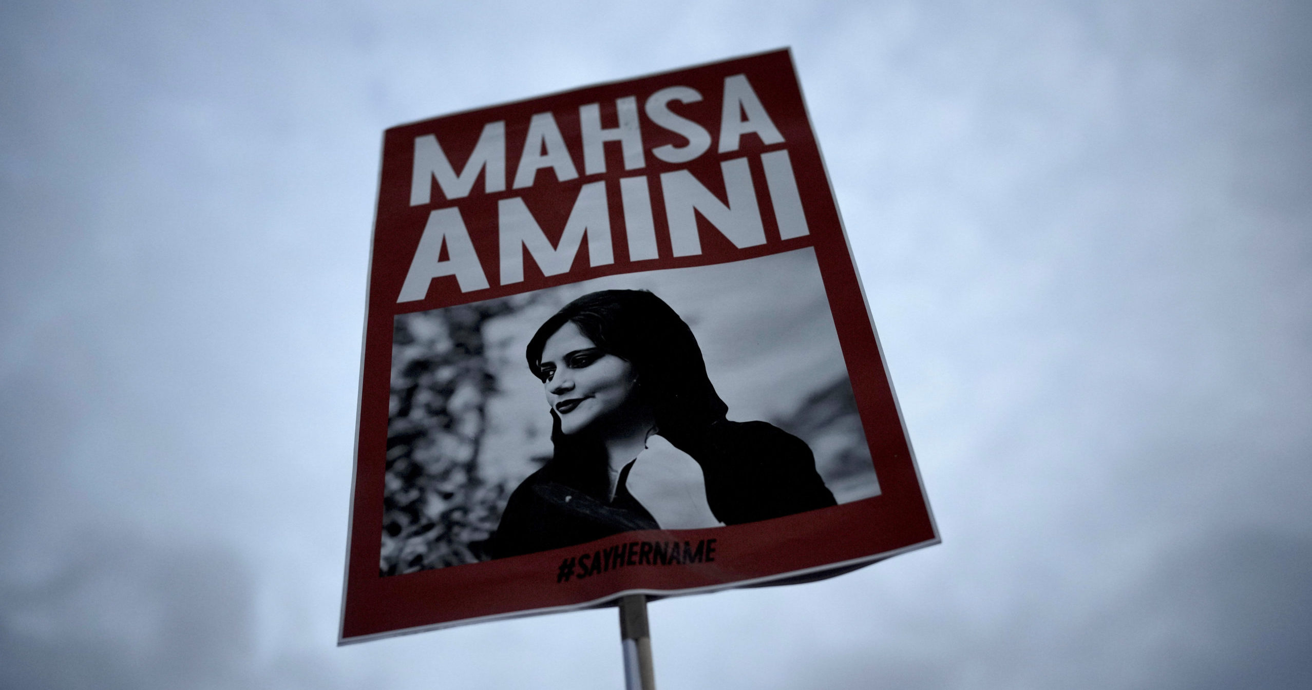 Demonstrators hold a placard with a picture of Iranian woman Mahsa Amini during a protest against her death, in Berlin, Germany, on Sept. 28, 2022.