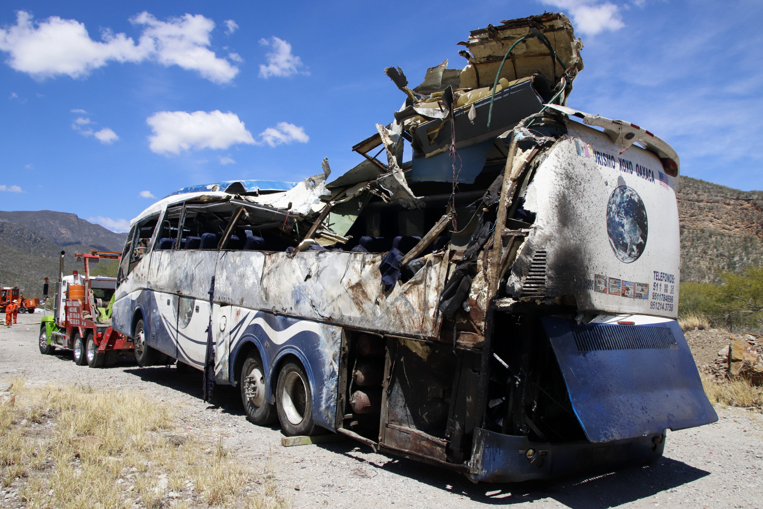 A bus involved in a deadly crash sits attached to a tow truck on the side of the road Friday near Tepelmeme, Oaxaca state, in Mexico.