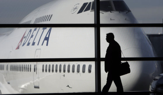 A passenger walks past a Delta Airlines 747 aircraft at Detroit Metropolitan Wayne county Airport in Romulus, Michigan, on Jan. 21, 2010. Several major airlines have announced they are cancelling flights in and out of Israel following the nation's declaration of war on Hamas.