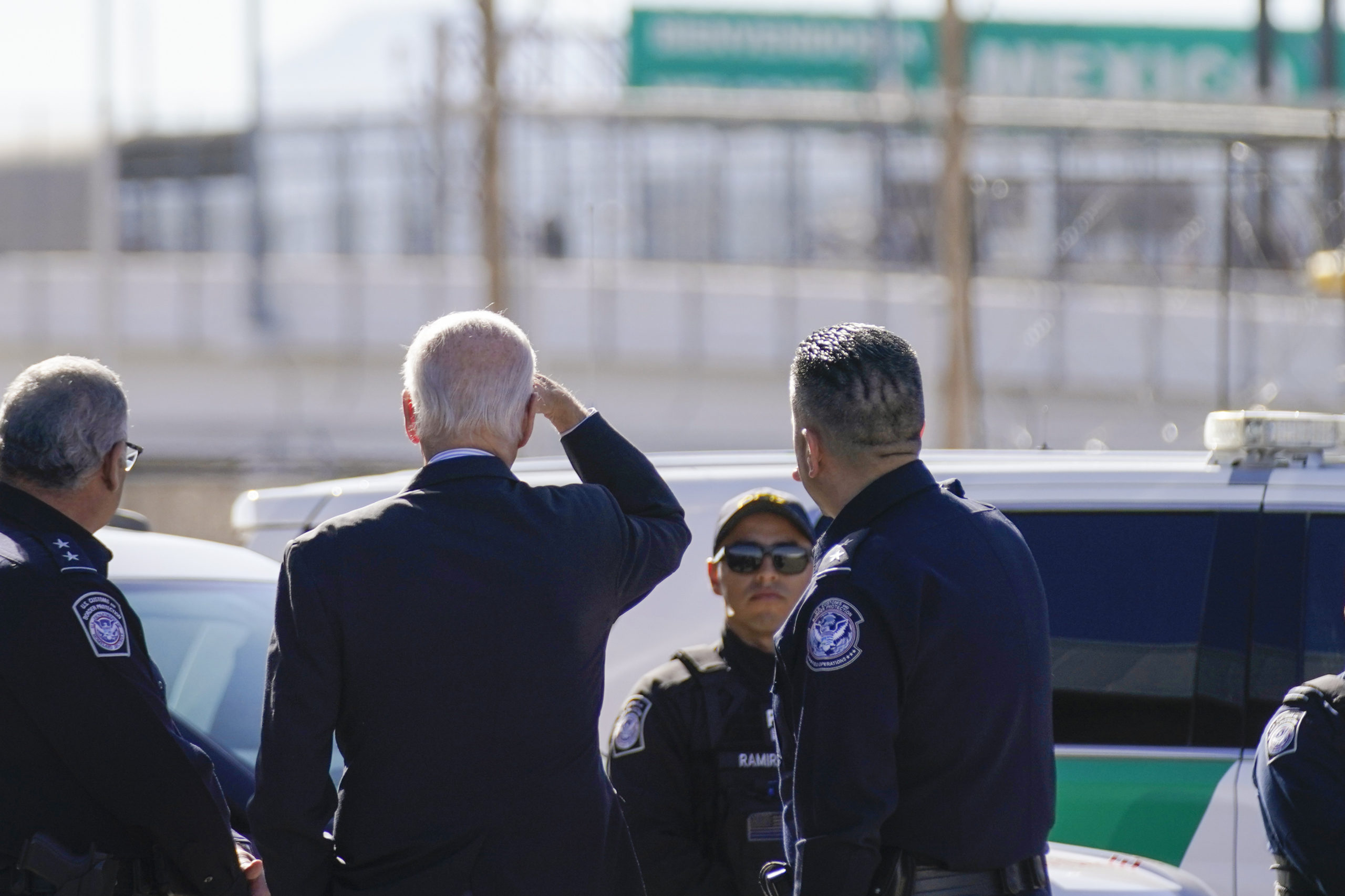 President Joe Biden, second from left, looks towards a large “Welcome to Mexico” sign that is hung over the Bridge of the Americas as he tours the El Paso, Texas, port of entry on Jan. 8.